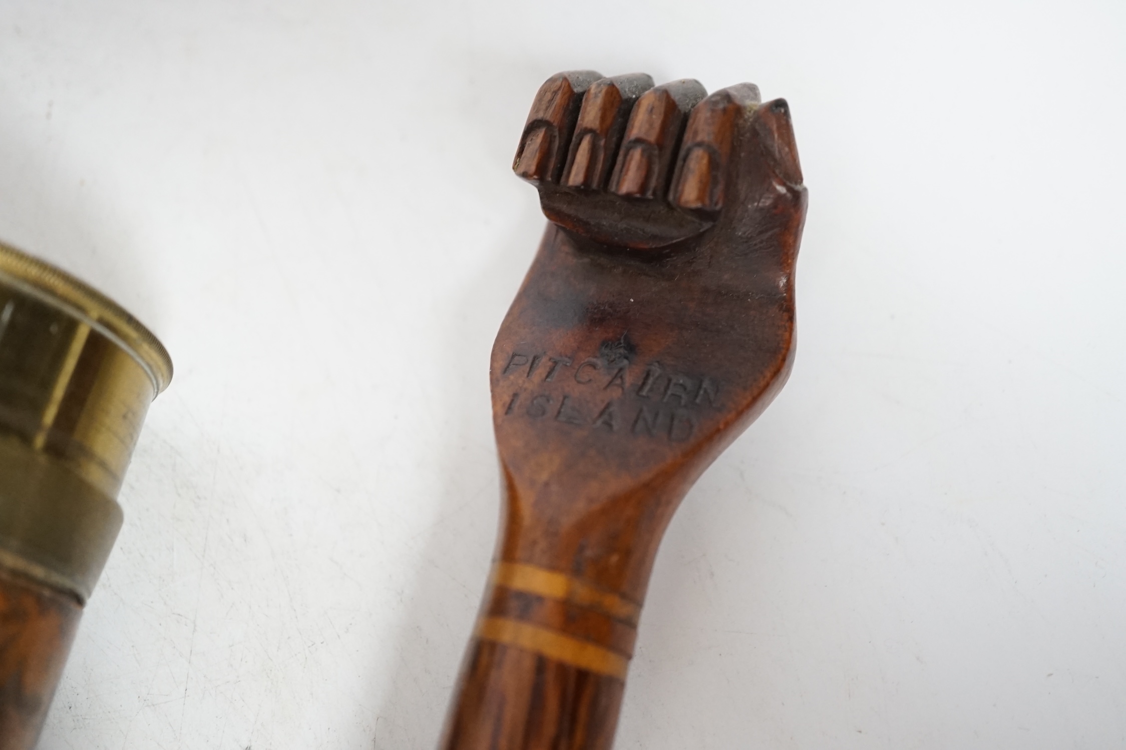 An inscribed cocus wood walking stick with carved handle in the form of a hand, ‘Pitcairn Island’ and a brass mounted two drawer telescope, largest 92cm in length